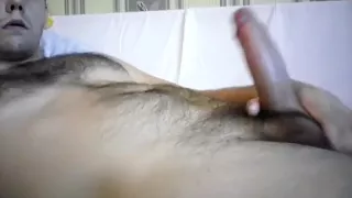 Bezaubernder Kerl vergnügt sich im Schlafzimmer und setzt sich vor der Webcam ein Denkmal