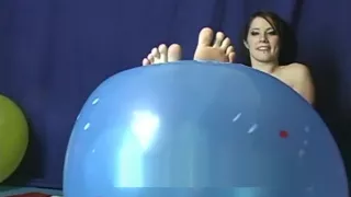Cute girl pointing her toes and showing her soles playing with balloon