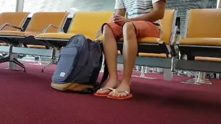 Junge zieht Flip Flops und Fußkettchen am Flughafen an