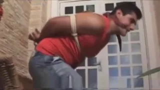 Alex Furkin gefesselt, geknebelt und mit einem Ballknebel in engen, kurzen Jeans