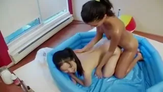 Two lesbian Asians having fun in a kiddy pool