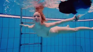 Redhead babe swimming naked in the pool