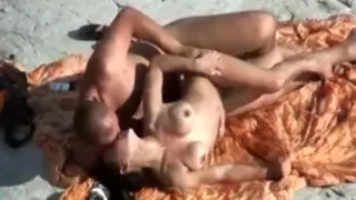 Une meuf sexy suce son mec et baise avec sur la serviette de plage