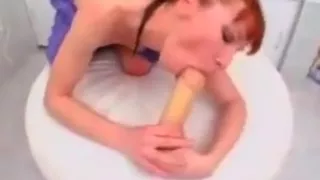 Redhead plays with her ass in the bathroom