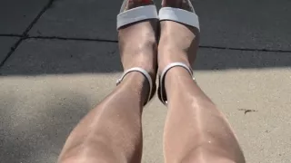 Rubbing shiny pantyhose legs outdoors