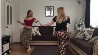 Two blonde girls dancing at home