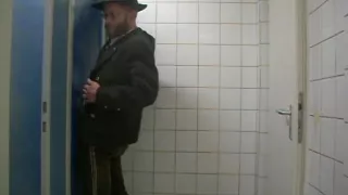 Bayernbursch wird in einem Gloryhole gewartet