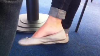 Candid dangling in grey flat barefeet