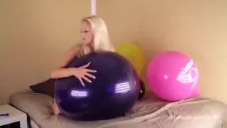 Blond girl bounce some big balloons