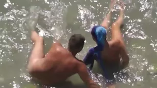 Girl sucks dick her boyfriend in the surf at a public beach