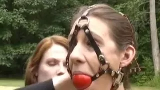 Redhead tortures brunette in public