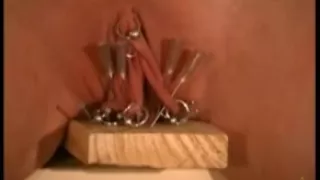 Villein cum-hole nailed on wood with needles and nails.