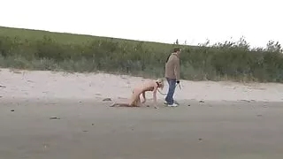 Slim blonde slave leashed and whipped on the beach