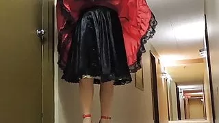 Sissy Ray im roten Teffeta-Kleid im Hotelflur