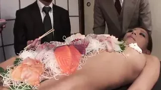 Business men eat sushi out of a naked girl&#039;s body