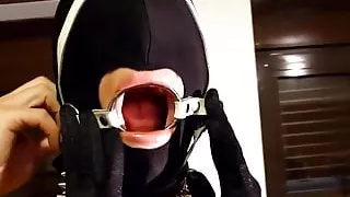 Putting hand made ring gag harness in slave slut mouth