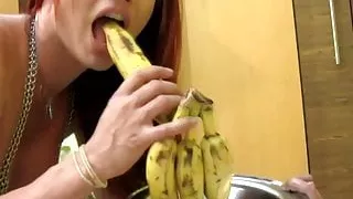 Rothaariges T-Mädchen im durchsichtigen Kleid genießt ihre Bananen-Rama