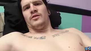 Tattooed stud tugging his hard cock and makes it squirt cum