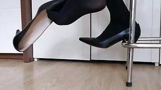 Shoe dangling and dropping black high heeled pumps in nylons