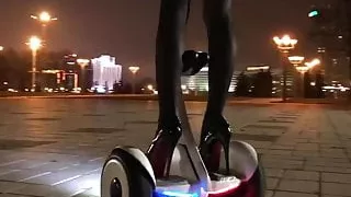 Hot girl driving gyroscooter in high heels and short skirt