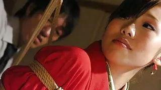 Tied up Asian bimbo sucks two cocks and gets toyed