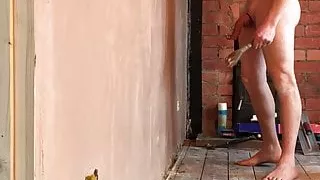 Nudist builder troweling up wall naked