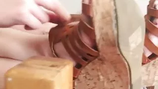 Pretty blonde removes wedge sandals and shows sweet soles.