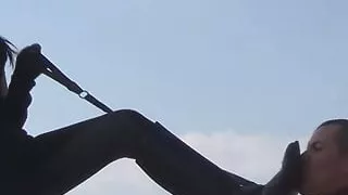 Masked goddess in leather whipping her slave