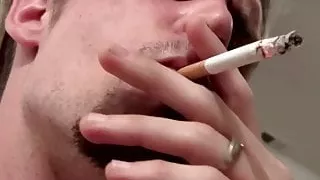 Tattooed chain smoker is stroking his cock for big cum load