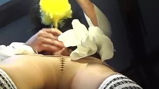 Crossdresser Sissy mit ihrem Staubwedel, der in der Garte klingt