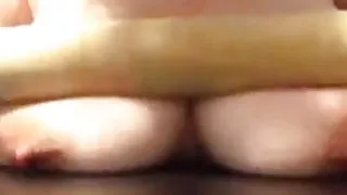 Crushing her own big tits with a rolling pin