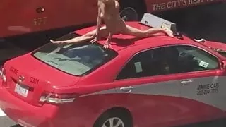 Woman dancing on a car in a busy street
