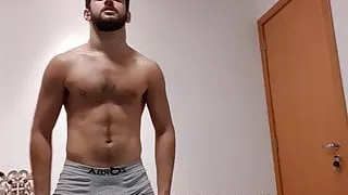 haariger Hengst, der seine verschwitzten, geschwollenen Muskeln nach dem Fitnessstudio beugt