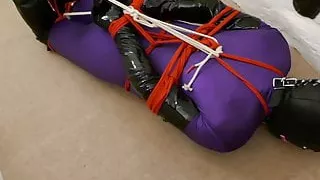 Kirsty mit Seil gefesselt, mit Kapuze und Ballknebel sicher