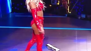 WWE - Carmella in red outfit standing over Sasha Banks