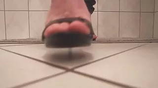 Walking on black sandal heels in bathroom with footjob