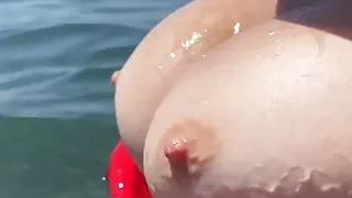 Beach slut takes off her bra and touches her big breasts.