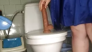 Curvy MILF pissing and fucking her dildo in the toilet