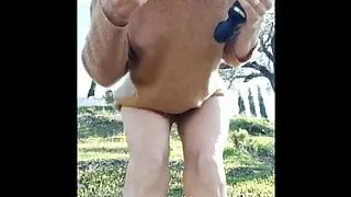 young woman masturbating with vibrator in the garden park