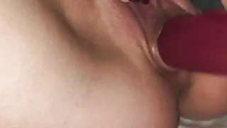 Eine nasse Muschi mit einem roten Dildo masturbieren