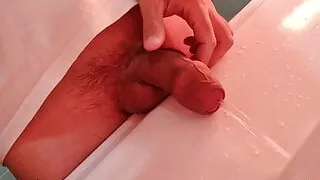 Young guy pissing in the washbasin