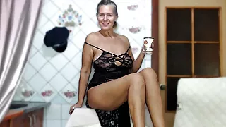 Lukerya in a black openwork dress on a washing machine