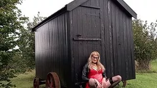 PVC-tragende Transe im Freien, die im Regen Sperma spritzt