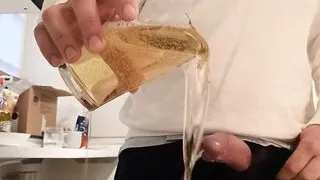 Verzweifeltes Pinkeln in ein Glas in der Küche