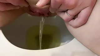 She pees in the toilet and touches her pussy