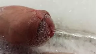 Close up pissing cock in the foam in bathtub