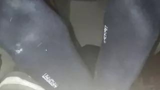 Blaue verschwitzte Socken und nackte Füße mit Cumshot