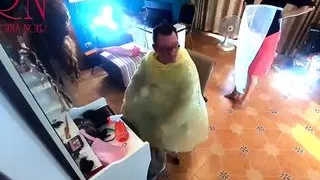 Nudist barbershop. Nude lady hairdresser in an apron. camera. The client is surprised. short 1