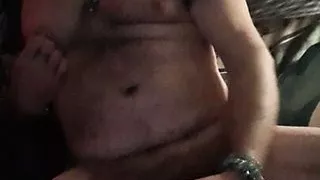 Ken sitting back, stroking his fat cock waiting for some company.