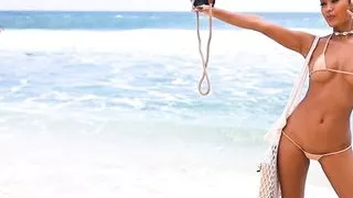 Putri Cinta stripping on a beautiful tropical beach